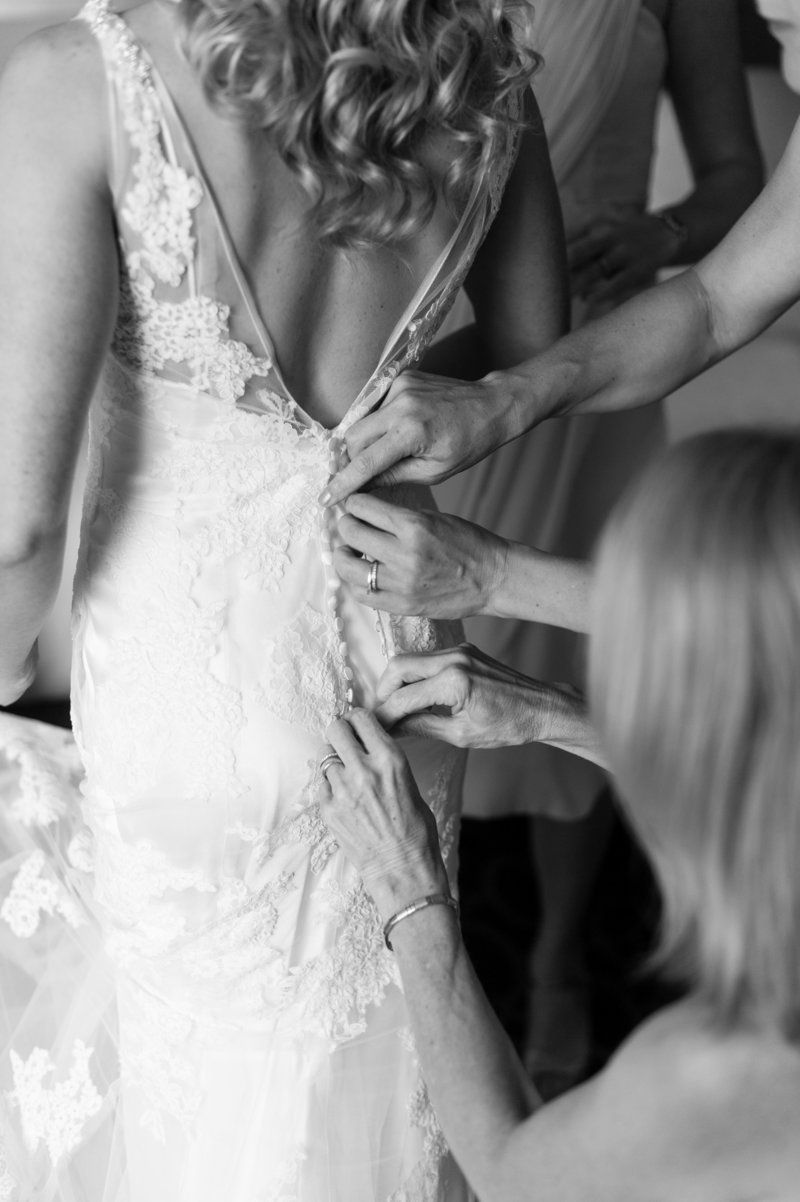 bride getting in wedding dress on wedding day